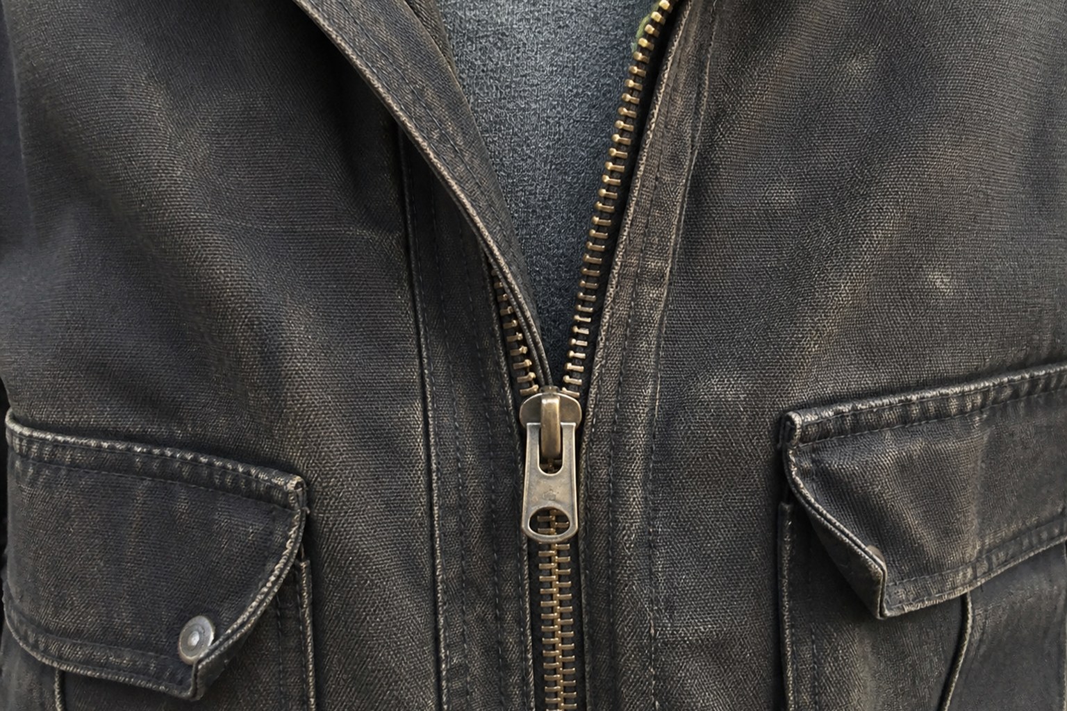 A heavy jacket zip stopped halfway, teeth closed below the slider and open above