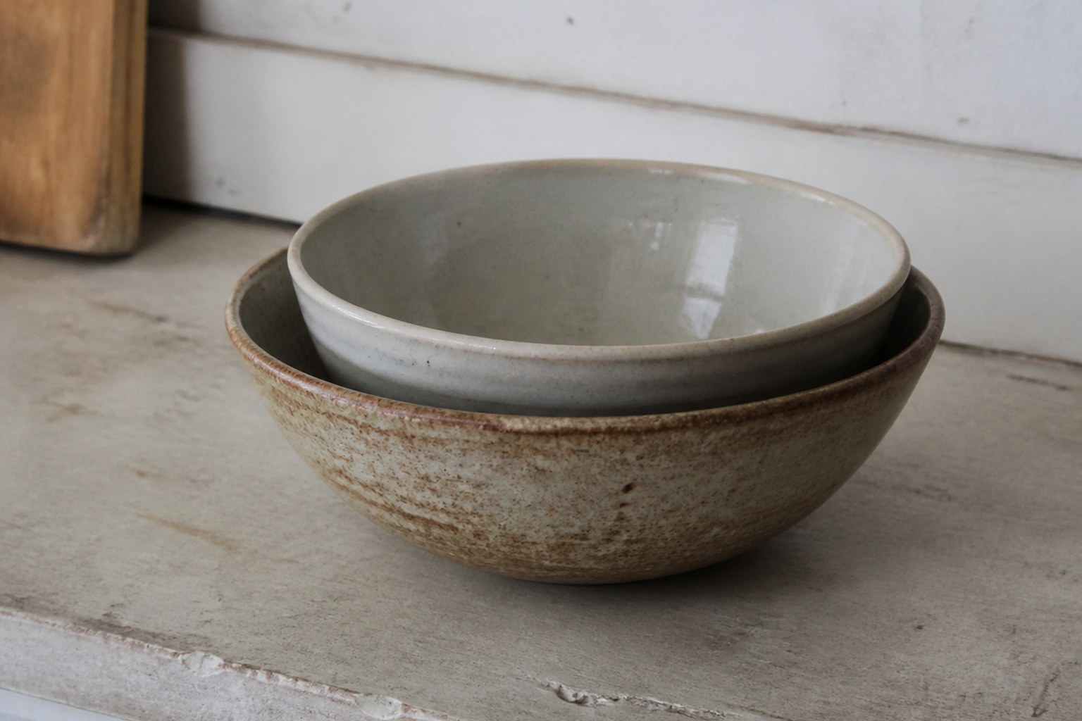 Two mixing bowls of different glaze nested inside one another