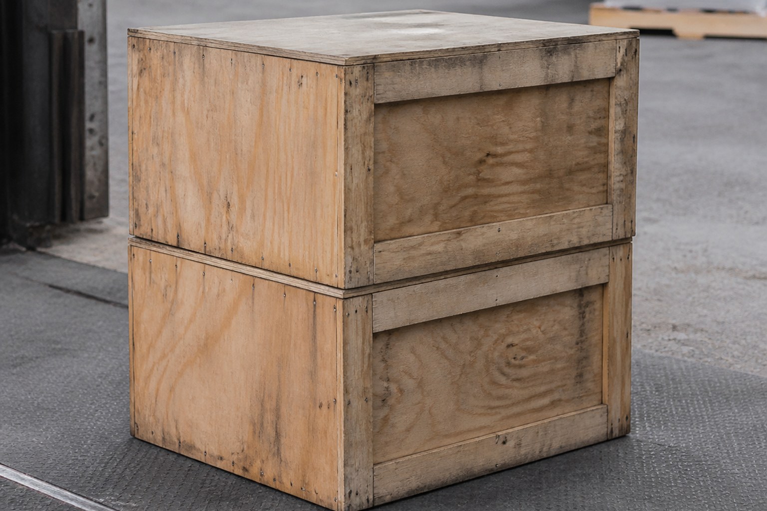 Two heavy wooden crates stacked square on a loading floor