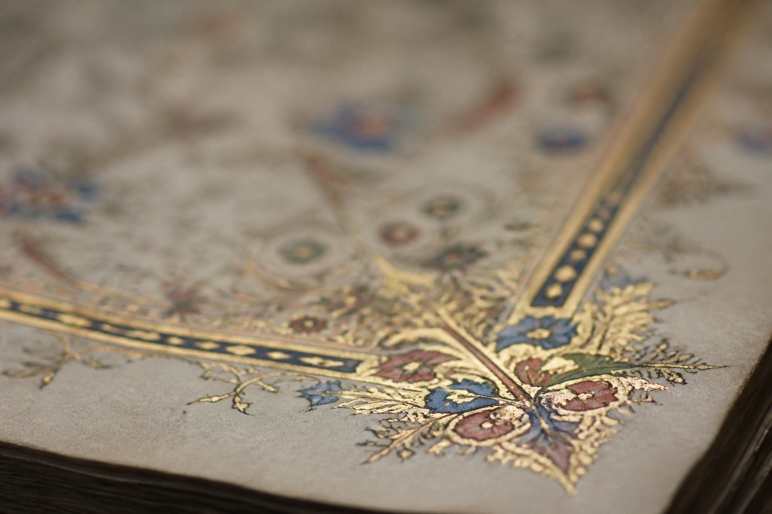 The gilded and painted corner of an illuminated manuscript page, gold leaf and ornament at the margin