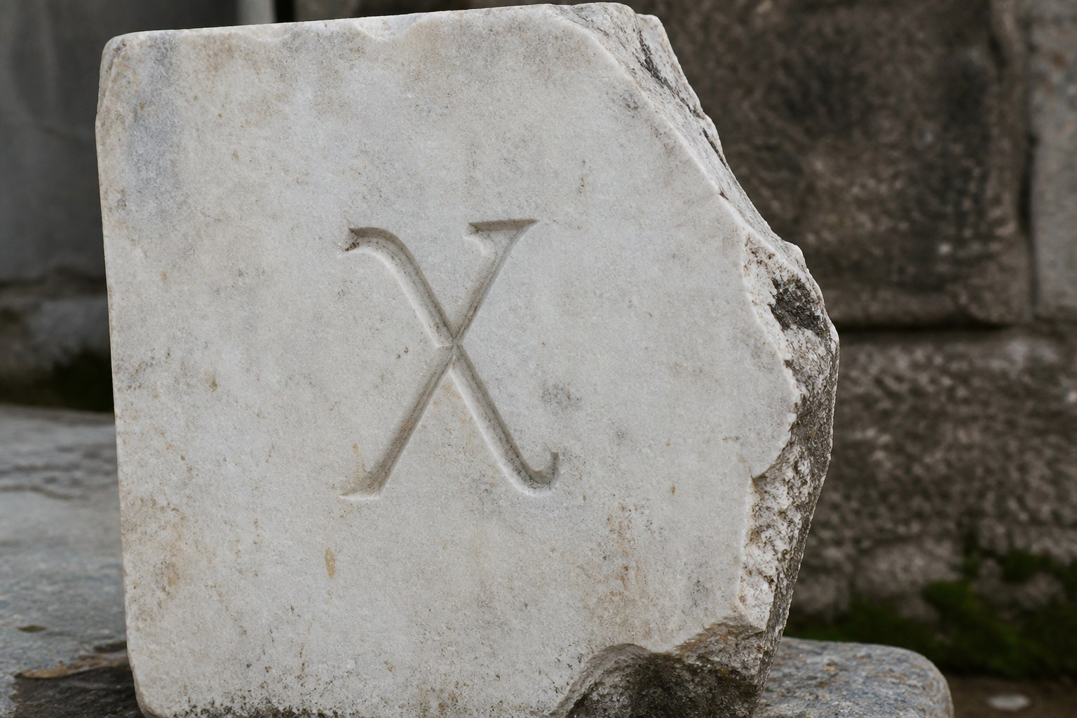 A single Greek letter cut into a weathered marble block