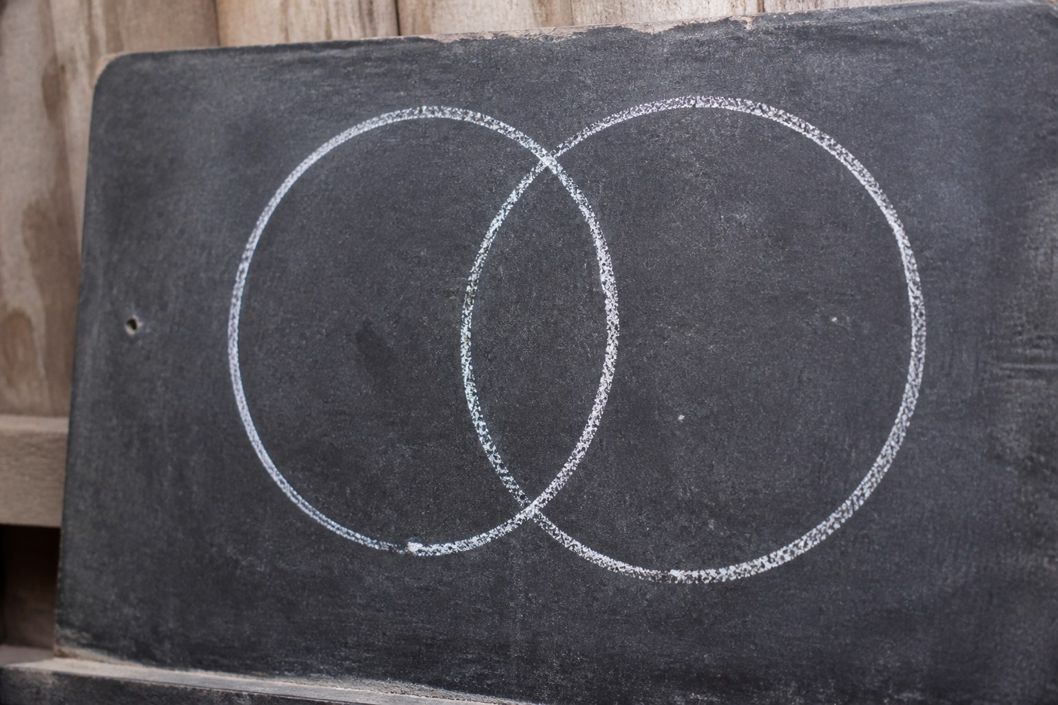 Two overlapping circles drawn in chalk on a dark slate
