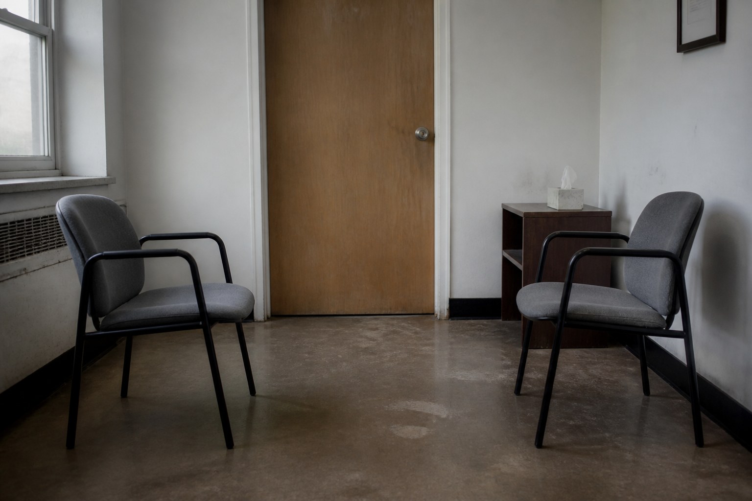 Two chairs facing each other in a small bare waiting room