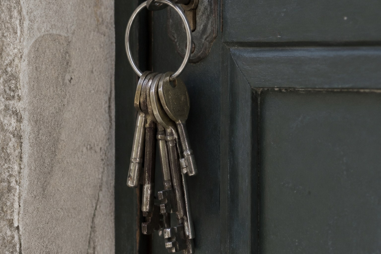 A ring of keys left hanging in the lock on the outside of a closed door