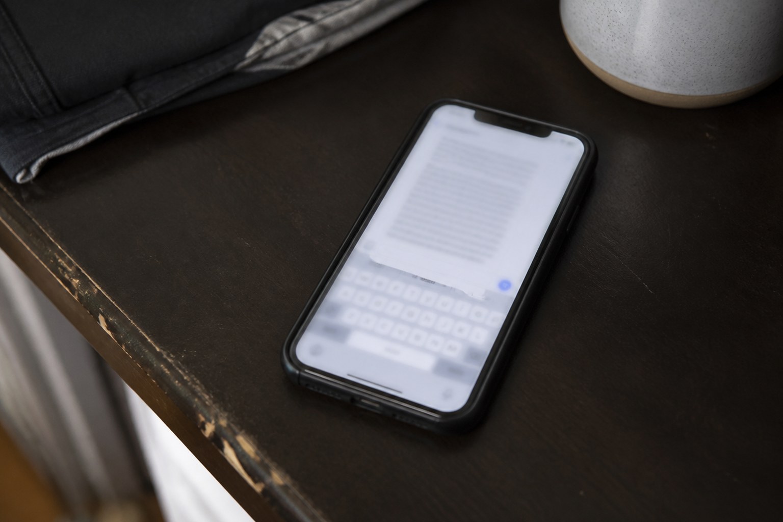 A phone face up on a table showing a long block of unsent typing