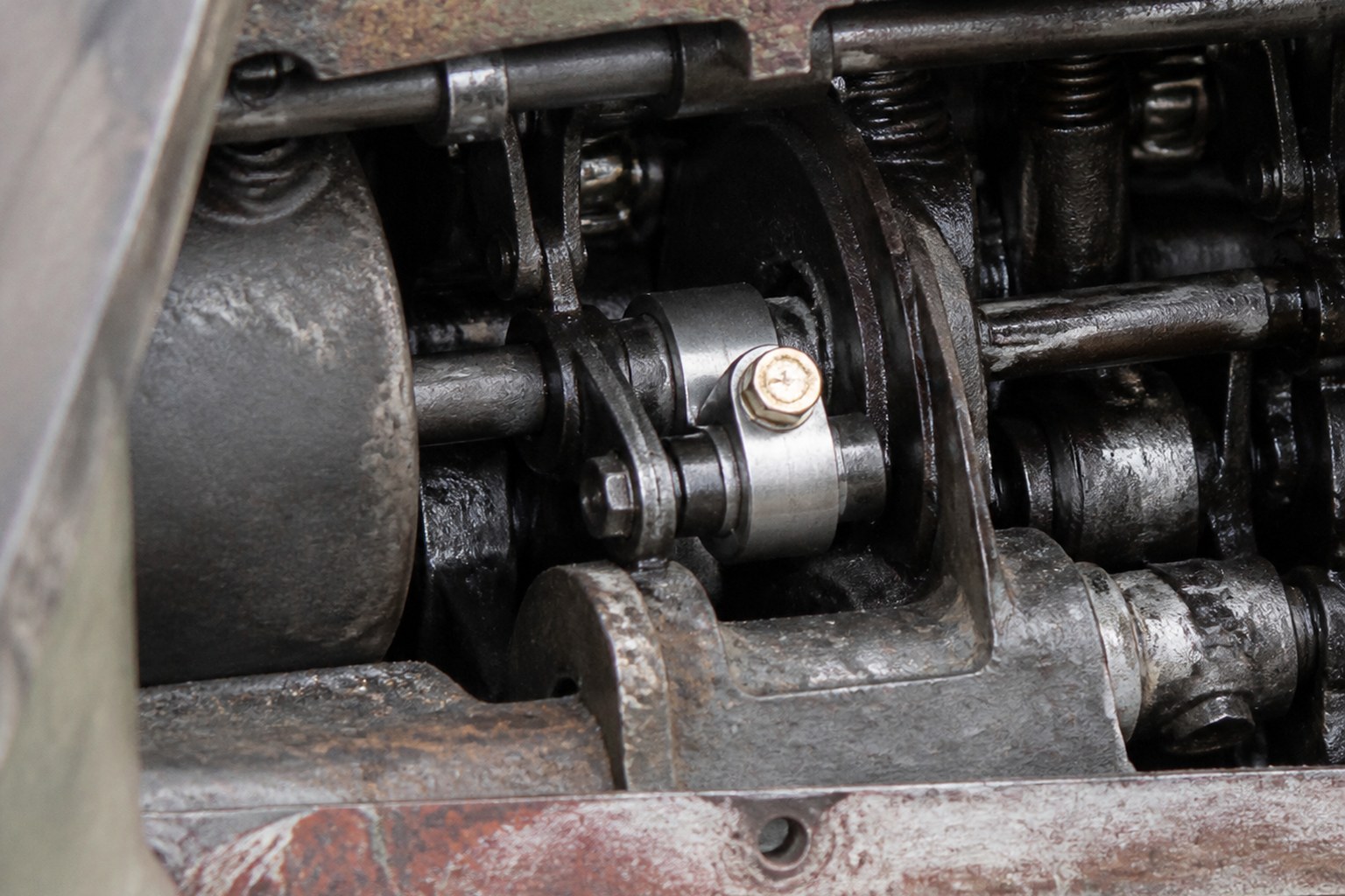 An old machine opened up with one bright new component among worn dark ones