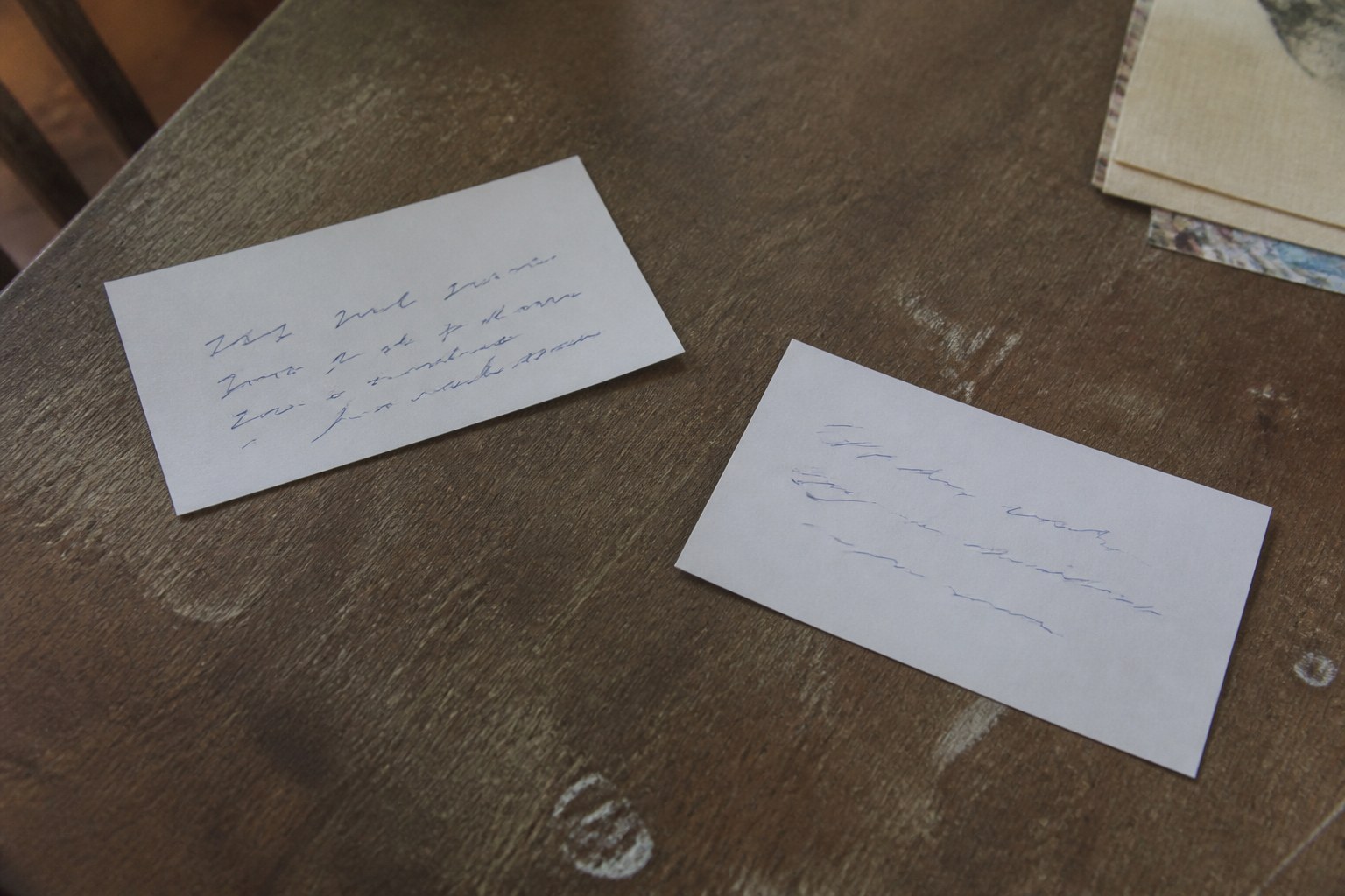 Two index cards laid apart on a table, each with a short handwritten line