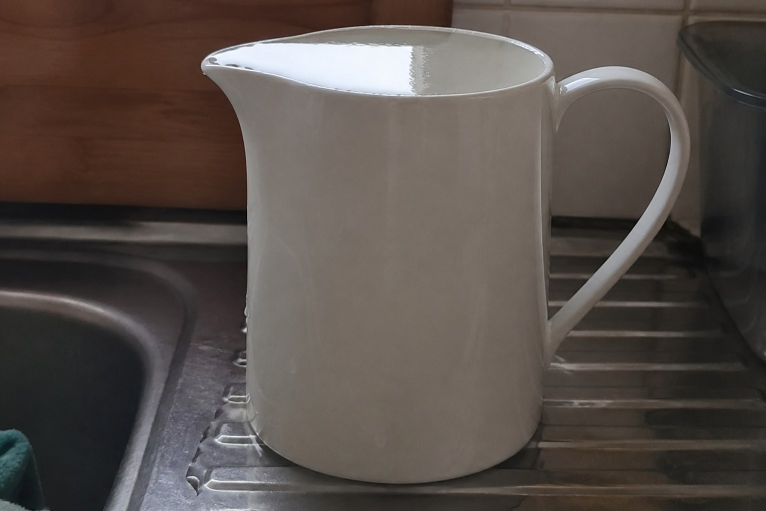 A jug filled to the brim with water standing around its base