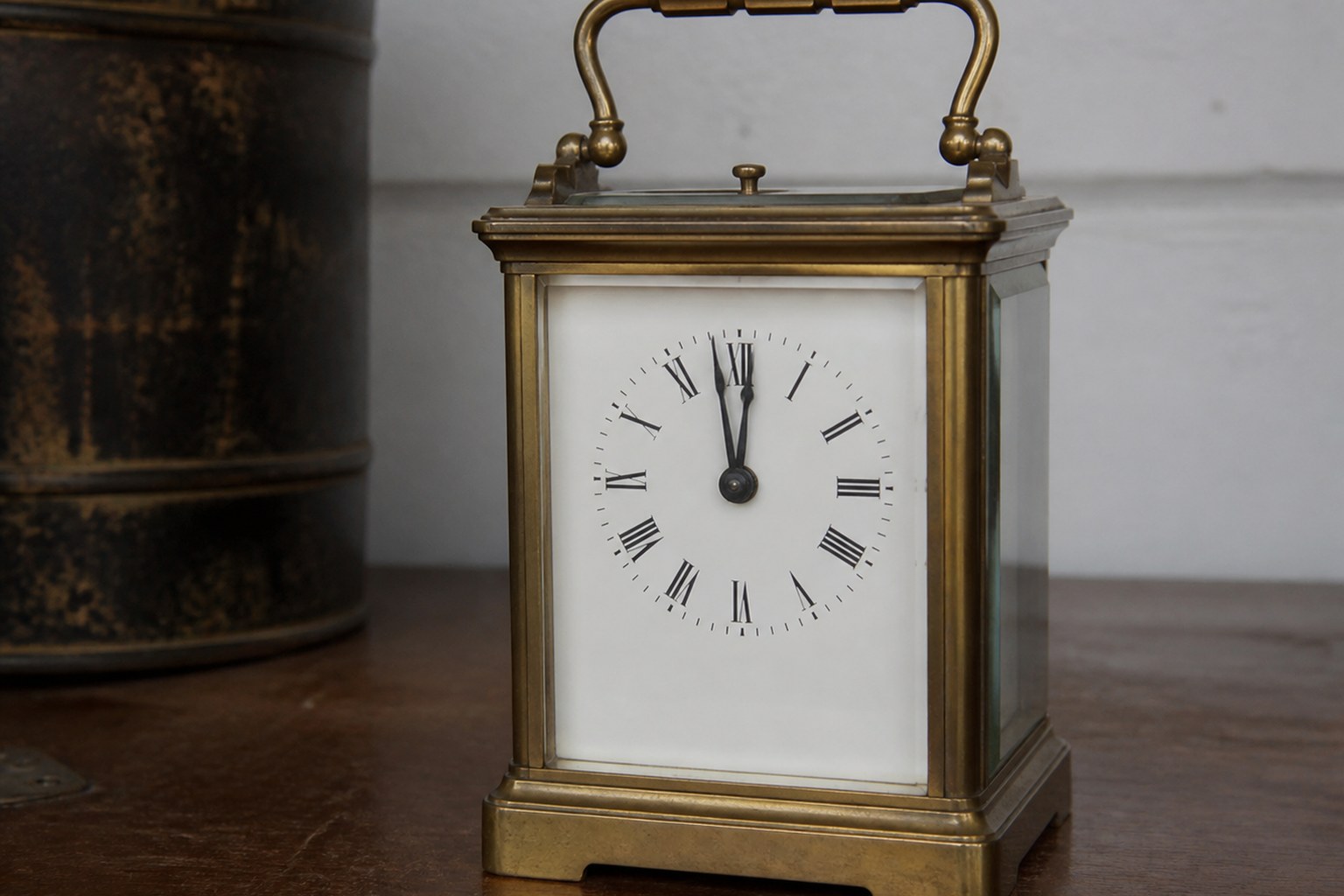 A brass carriage clock with both hands near the top of the dial