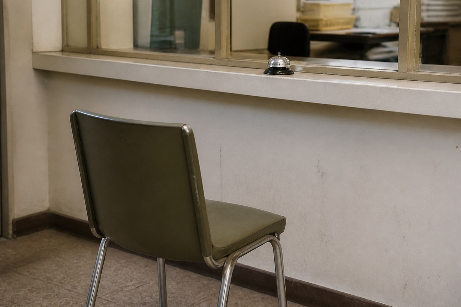A chair pulled up to a service counter hatch