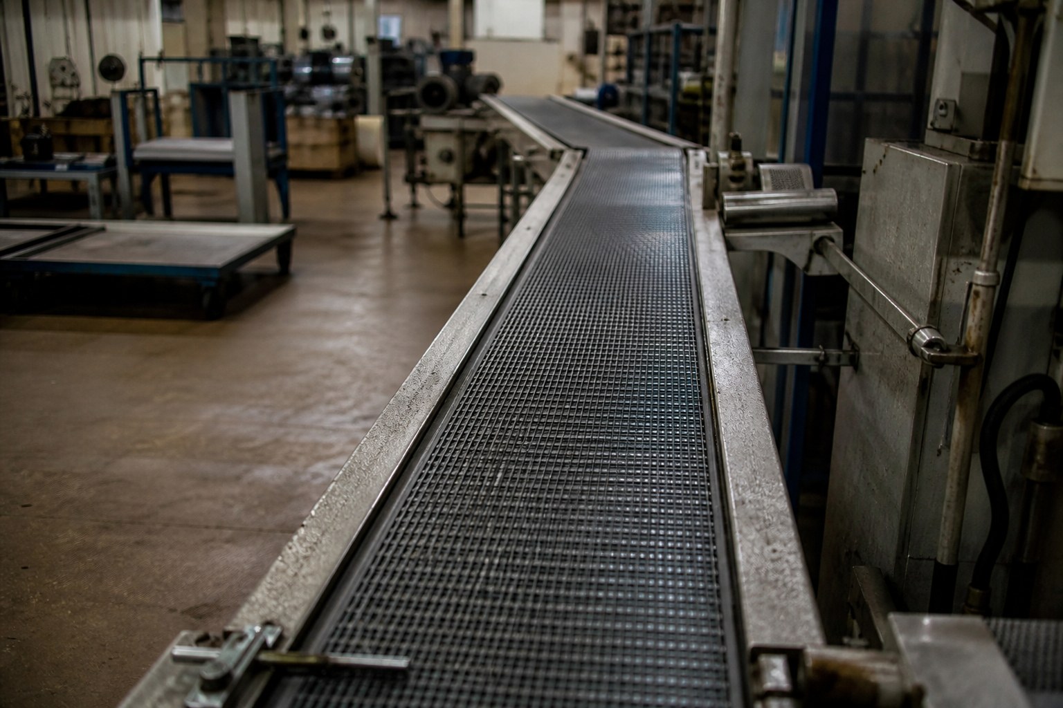 A factory conveyor belt running empty with the lights still on