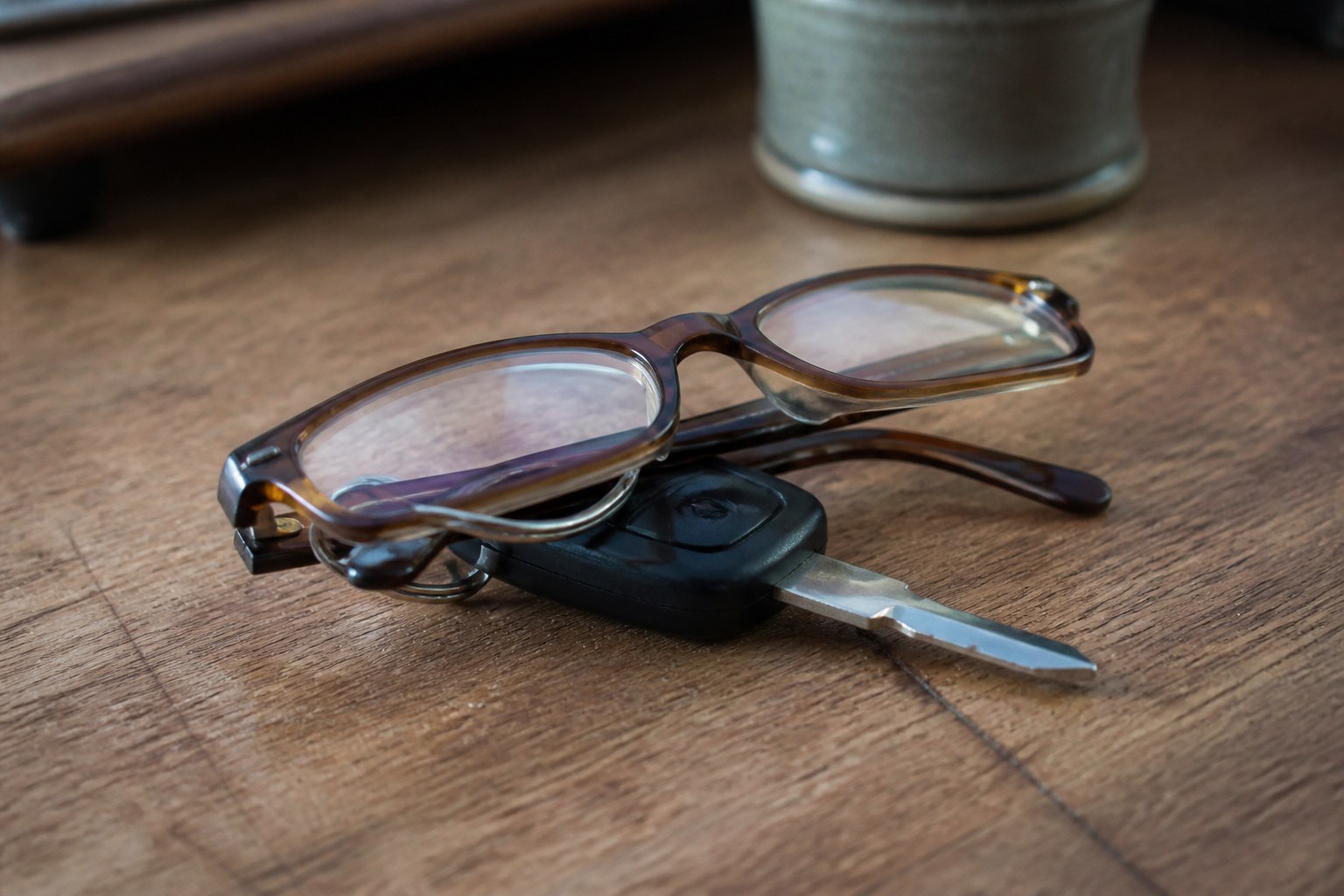 Folded reading glasses resting on a set of car keys