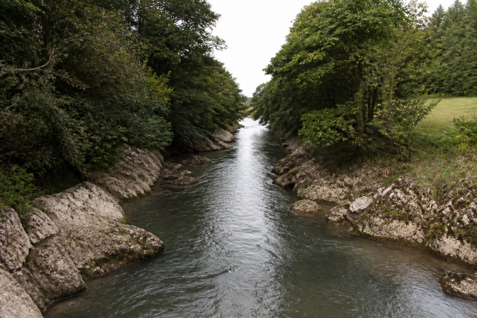 A river narrowing between banks into a single deep channel