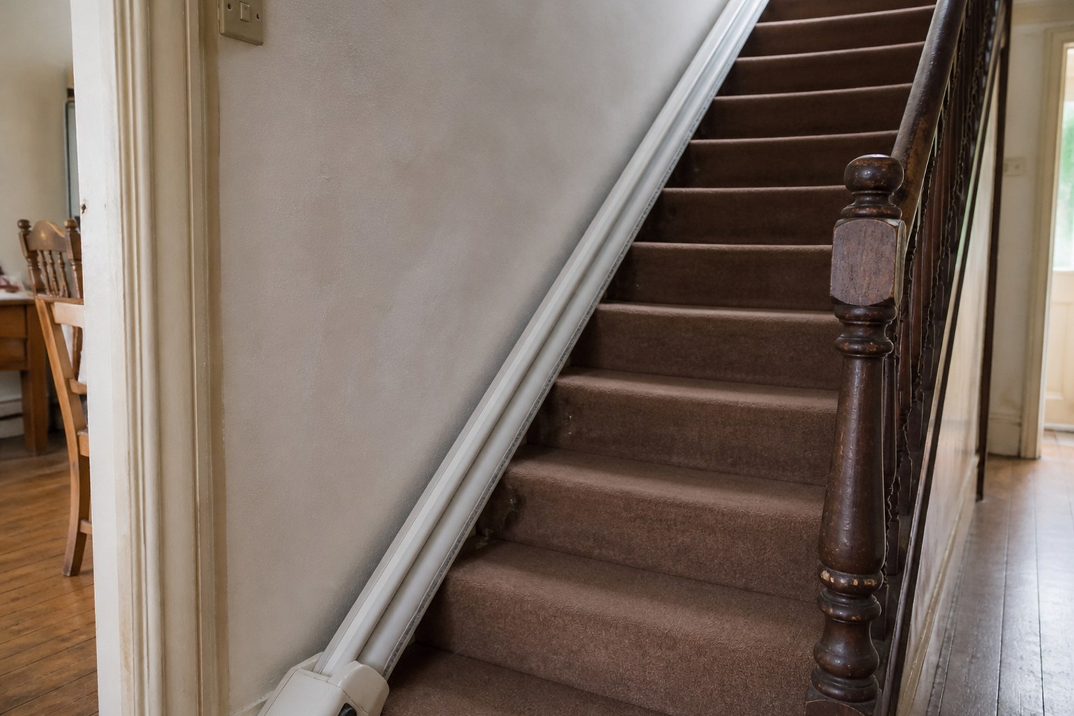 A stair lift track fitted along a domestic staircase