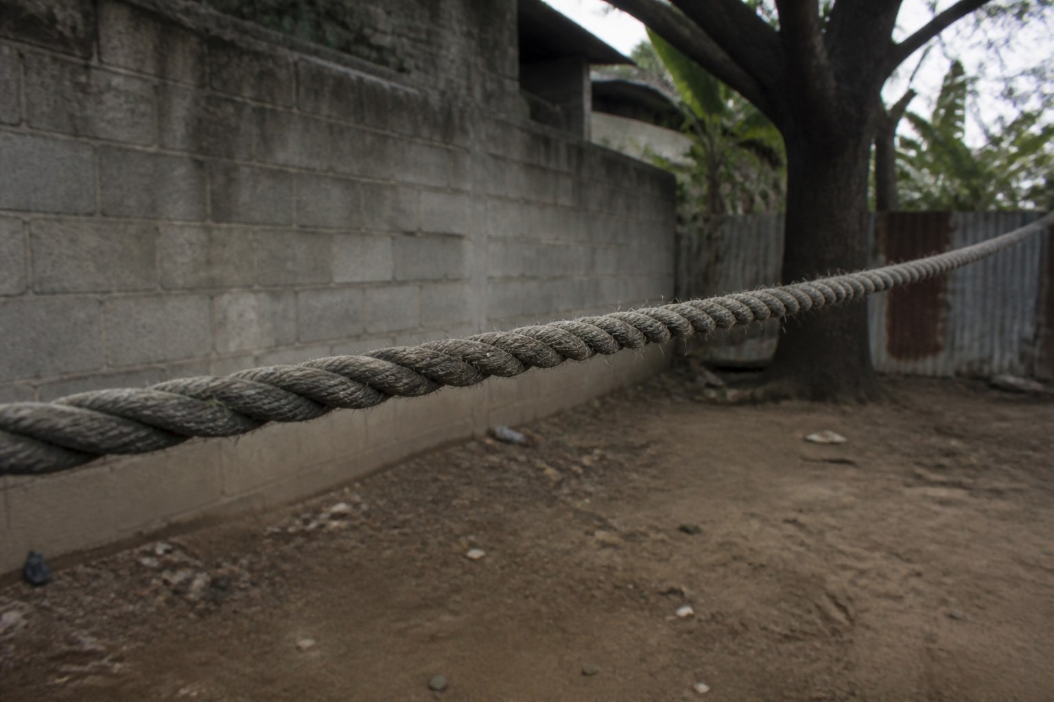 A thick rope stretched taut across a yard with nobody at either end