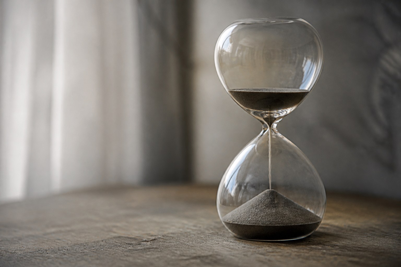 A glass sand timer part run through, the fallen sand mounded in the lower bulb