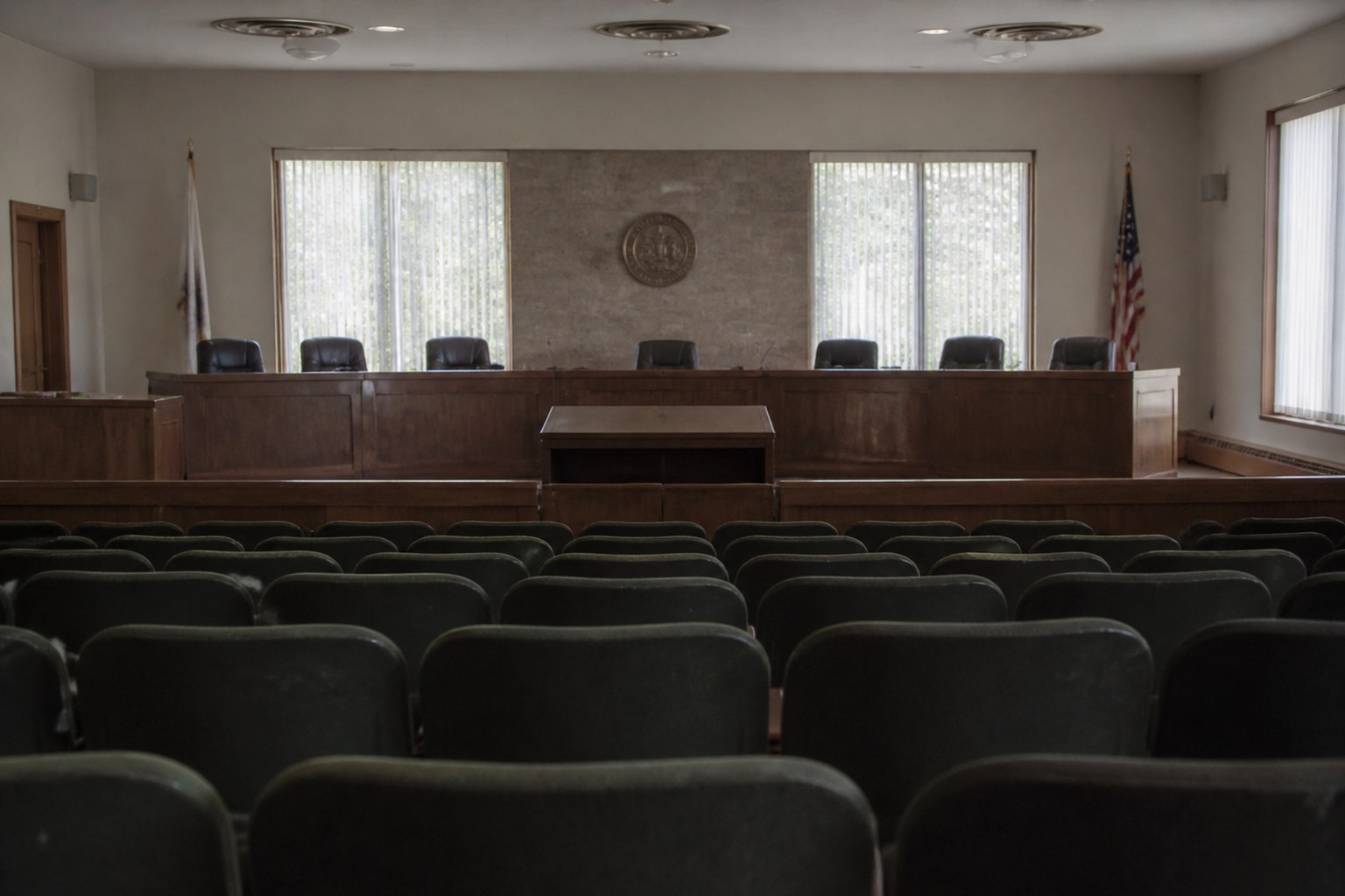 A council chamber with rows of empty seats facing a raised bench