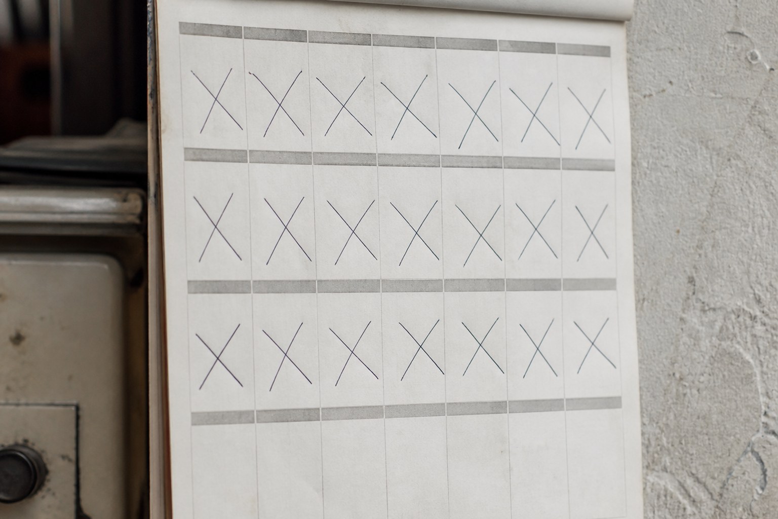 A wall calendar page with three consecutive weeks struck through in pen