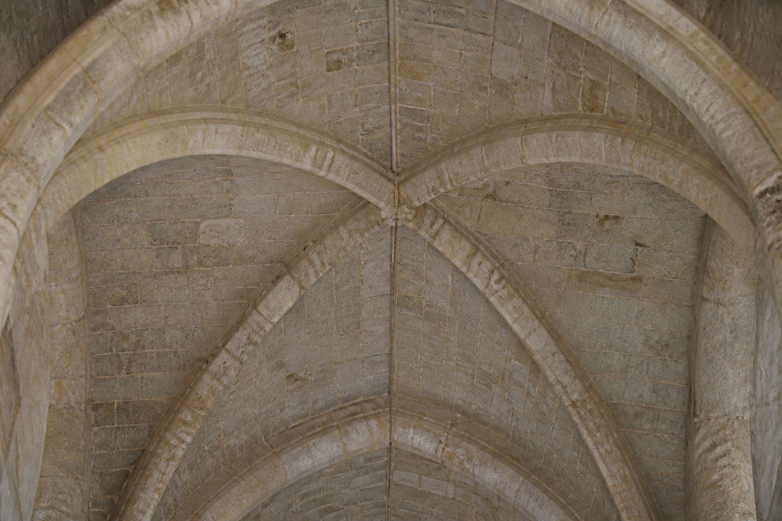 A high plain vaulted stone ceiling seen from directly below
