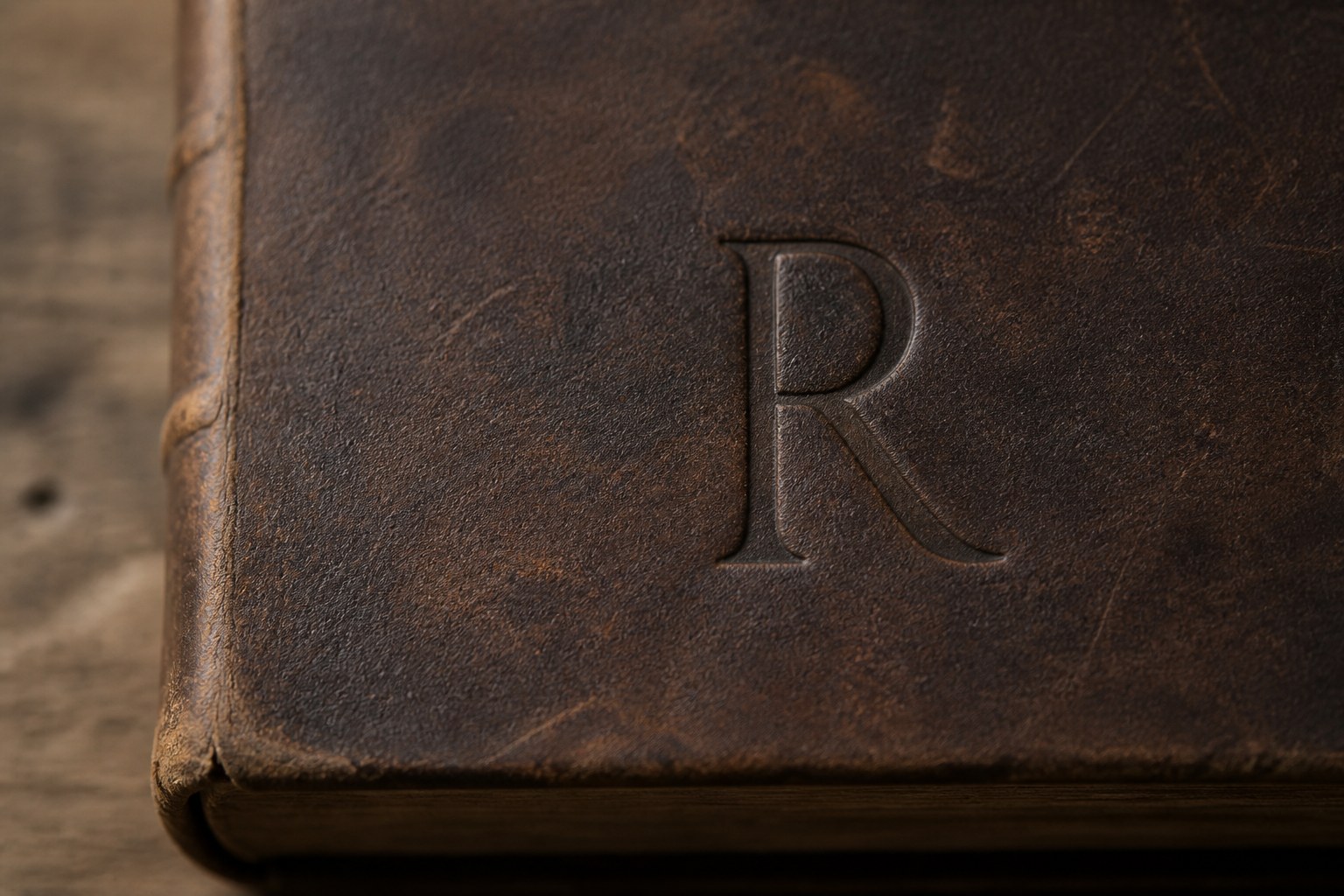 The capital letter R tooled and blind stamped into the leather cover of an old book