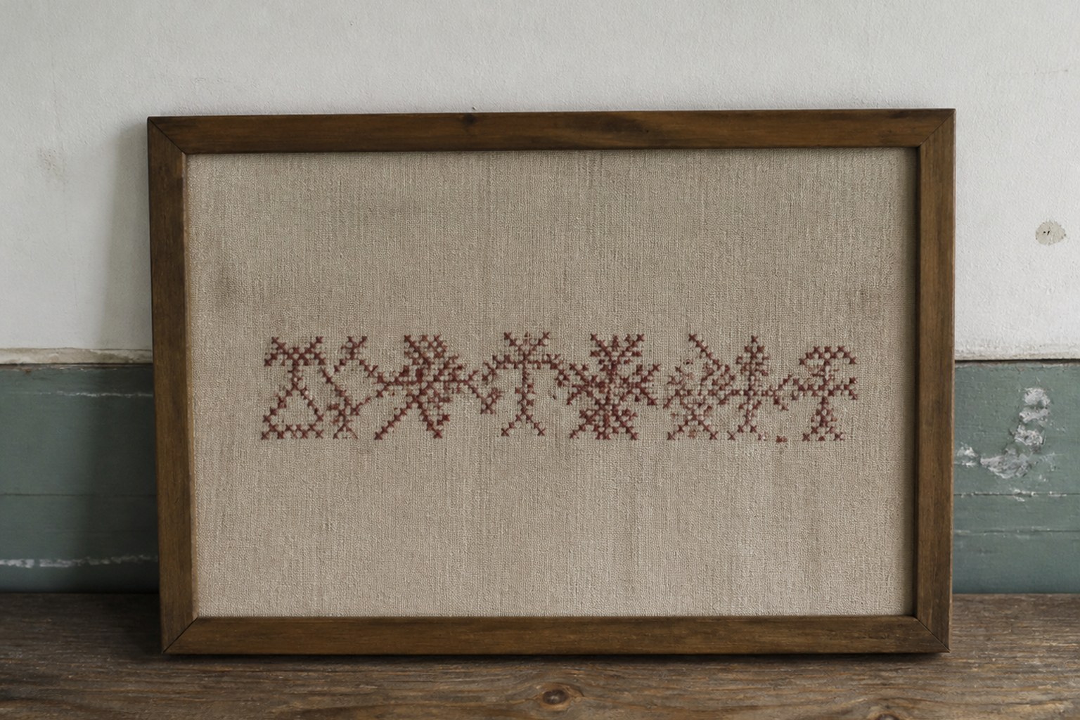 An embroidered linen sampler with a single word stitched across it