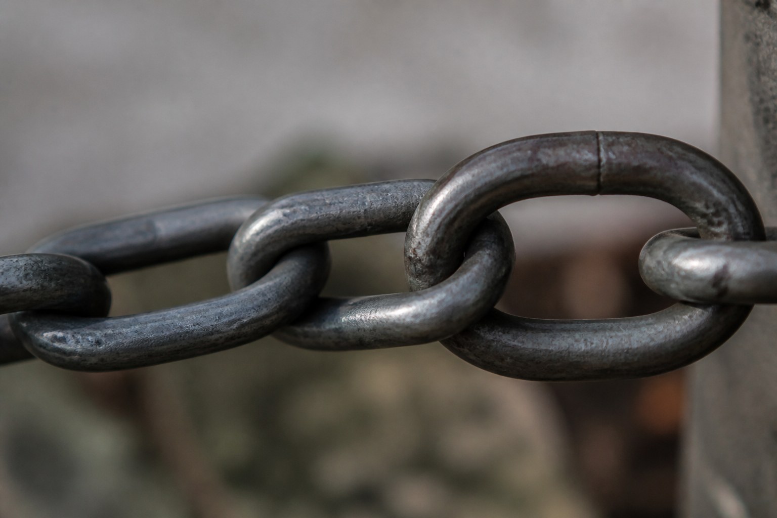 A single chain link closing around the last link of another chain