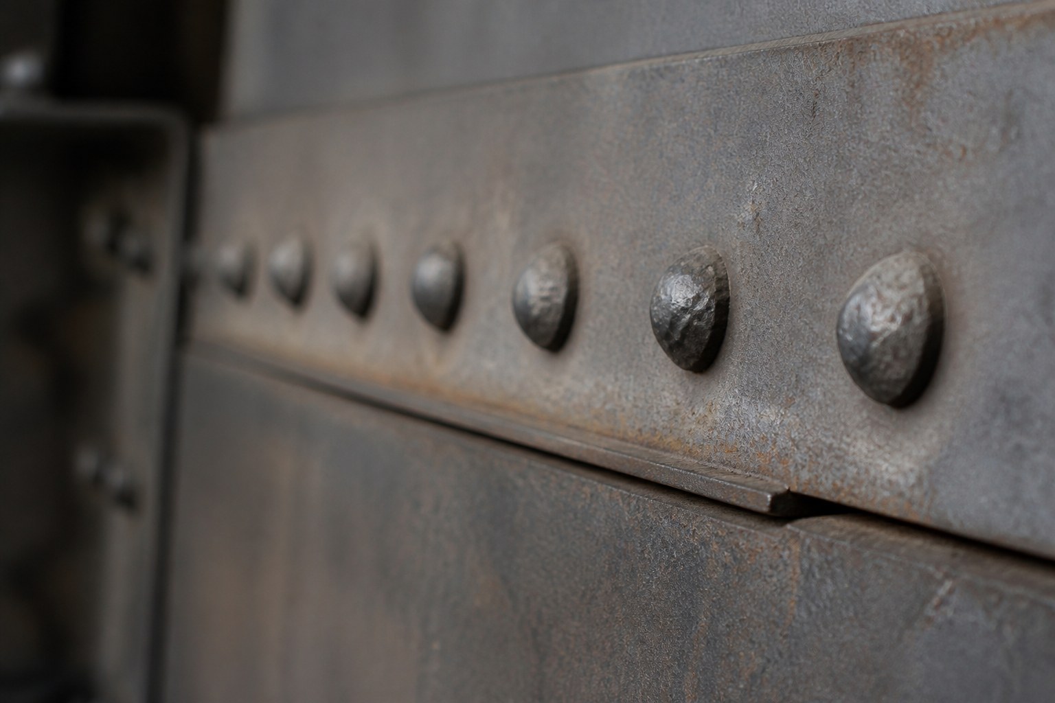 A row of hammered rivets joining two overlapping steel plates