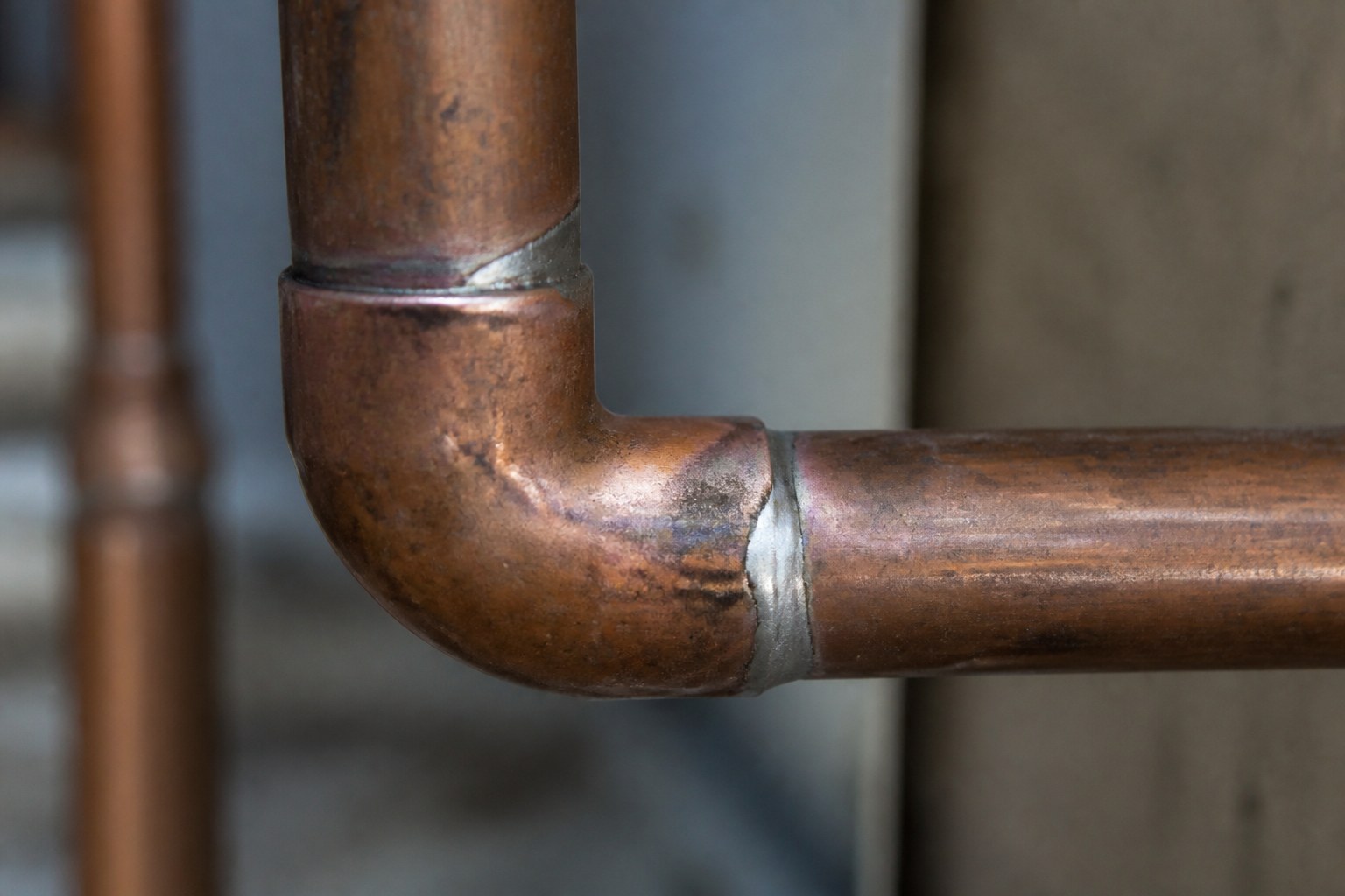 A soldered copper pipe joint, the fillet bright against the dull pipe