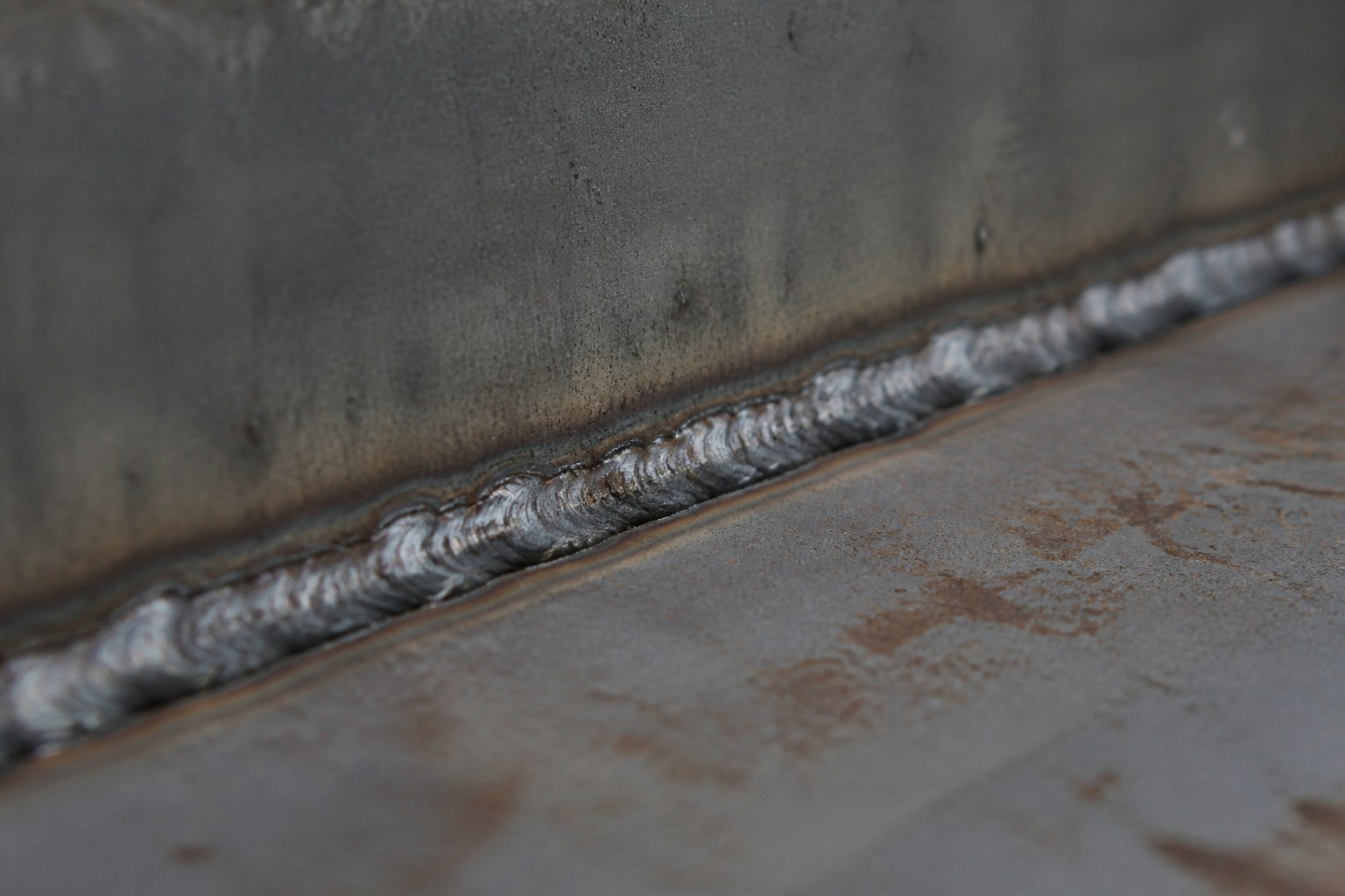 A welded seam running along the meeting edge of two steel sheets