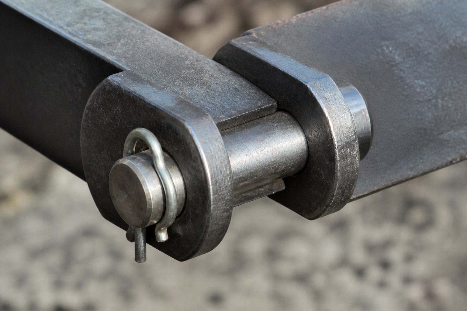 A clevis pin and split cotter holding two flat steel bars