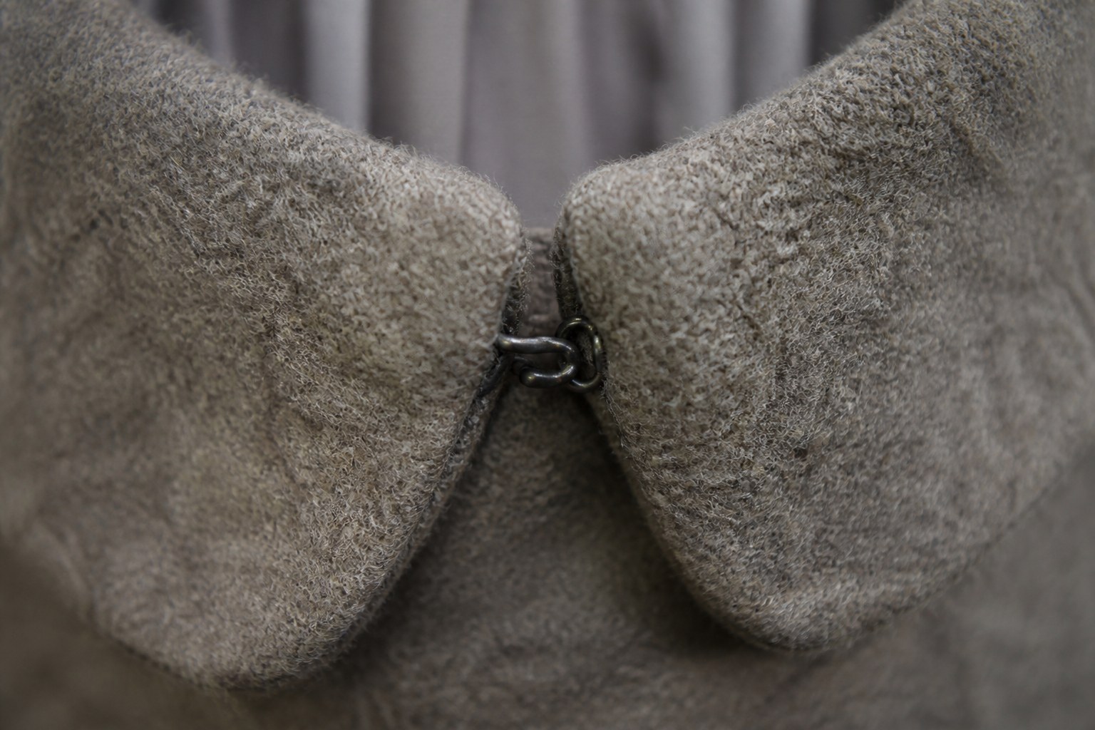 A hook and eye fastening closed on a woollen collar