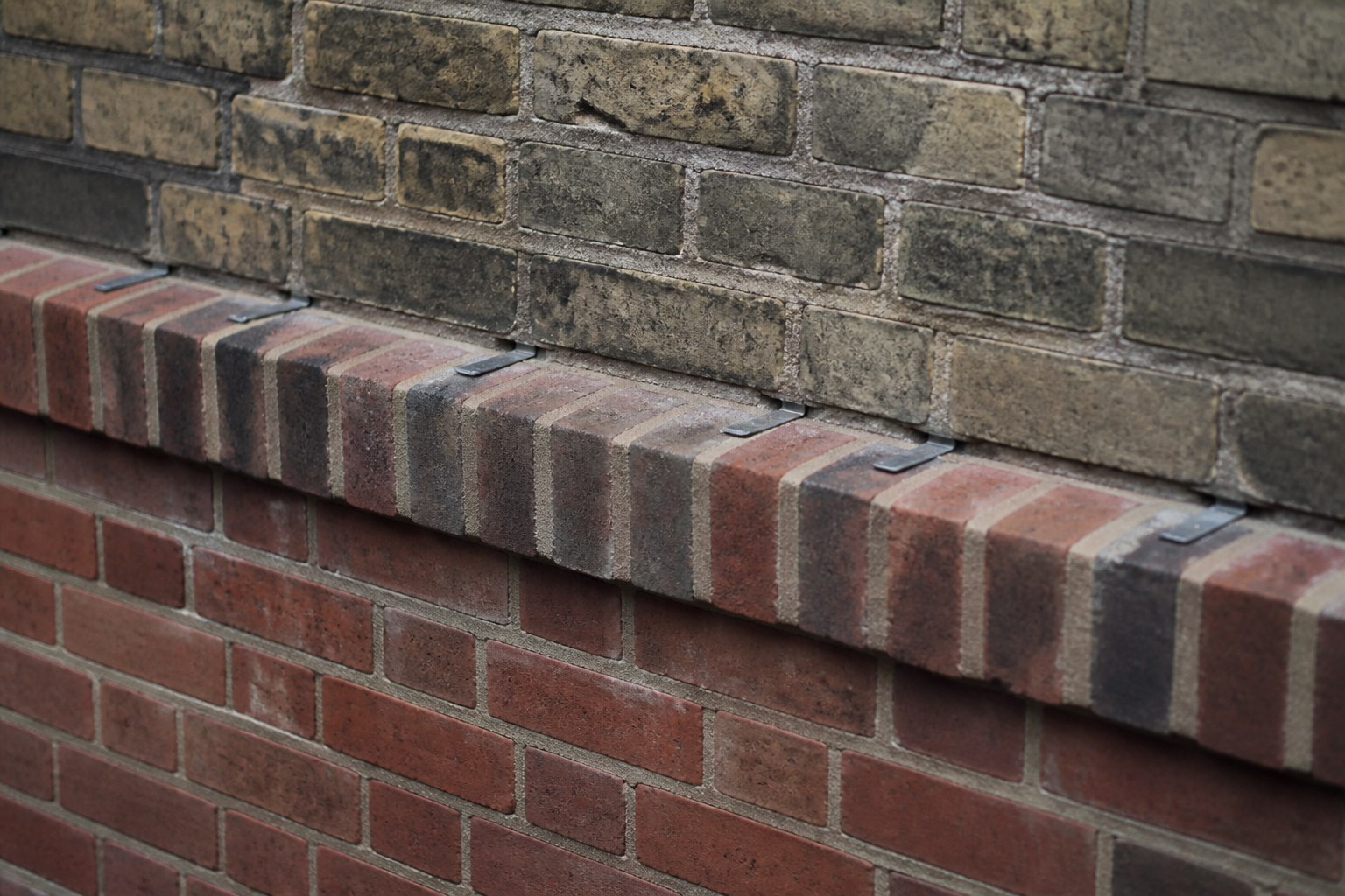 A brick wall showing a header course tying two skins together