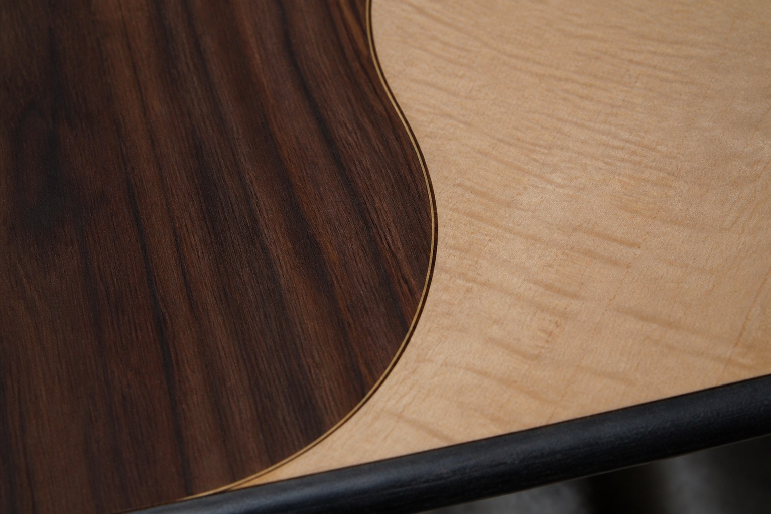 A marquetry veneer join where two different woods meet in a curve