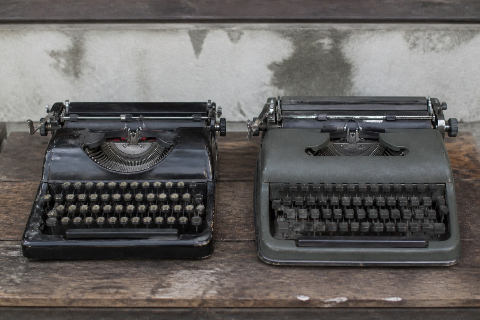 Two old typewriters side by side with visibly different key layouts